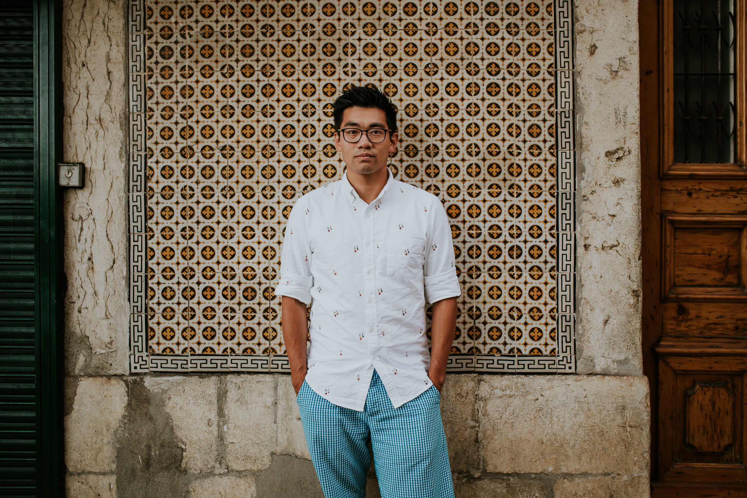 asian man in lisbon street with tiles in background