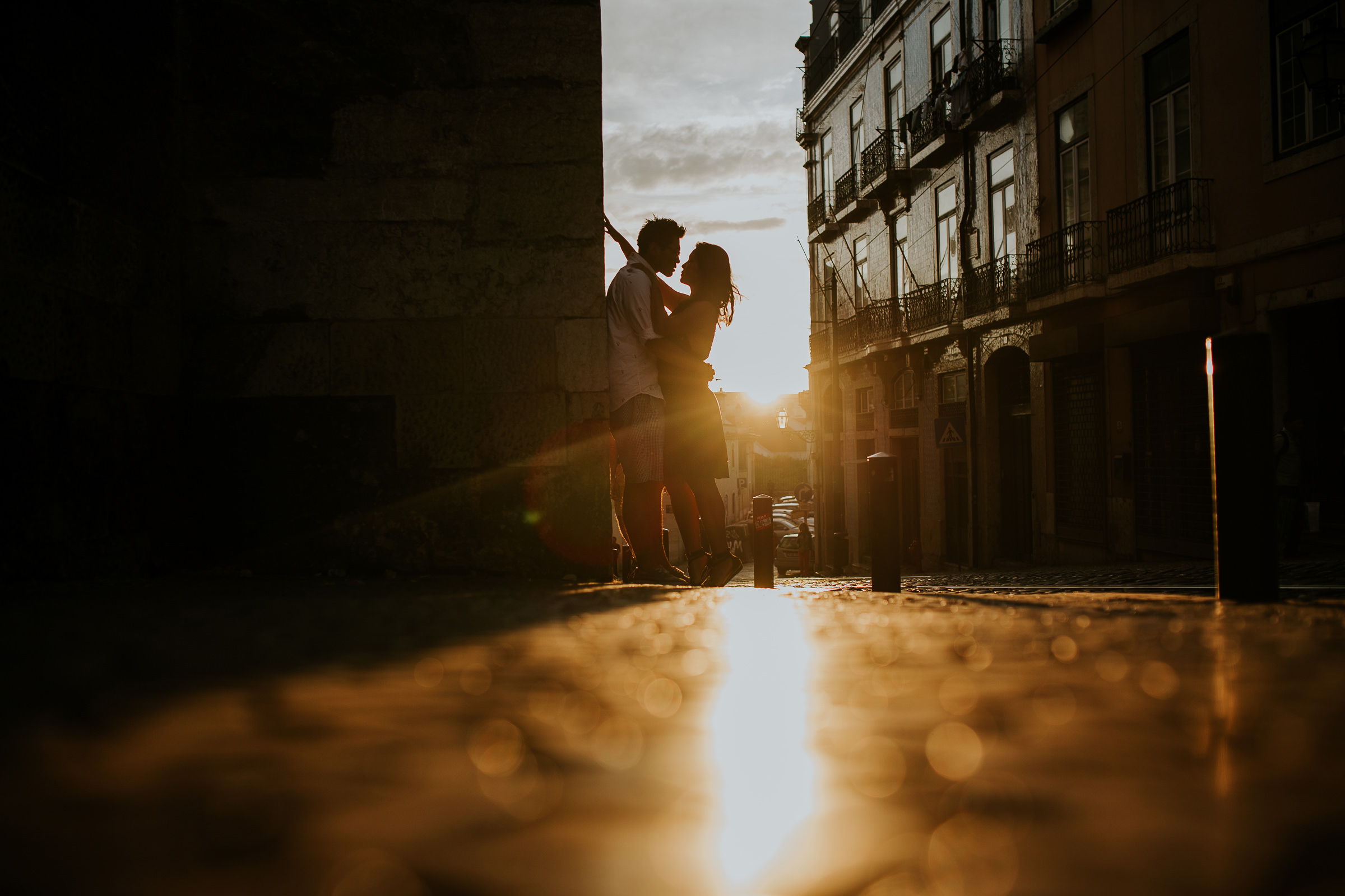 asian couple embraced during the sunset in lisbon streets
