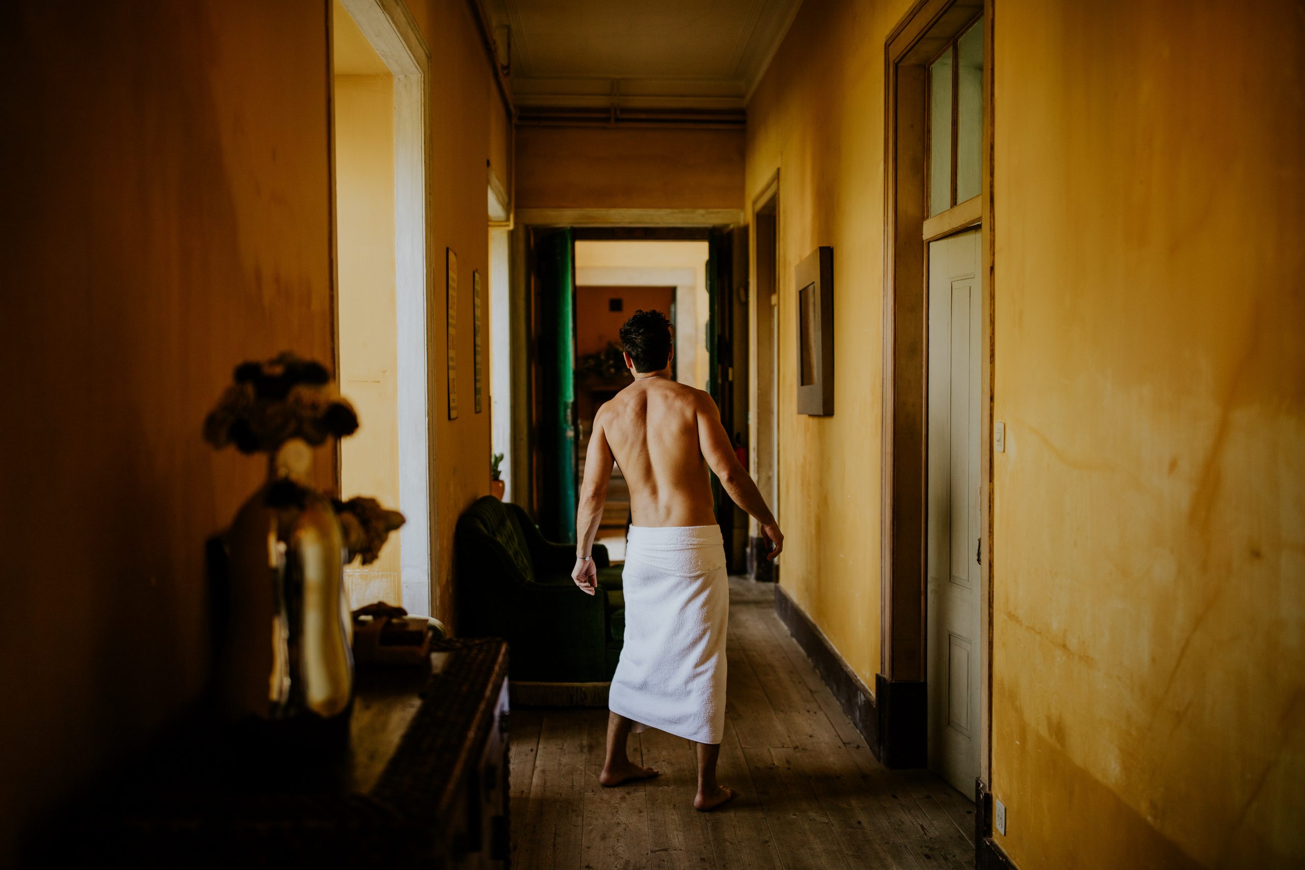 man half naked on the corridor with the bath towel