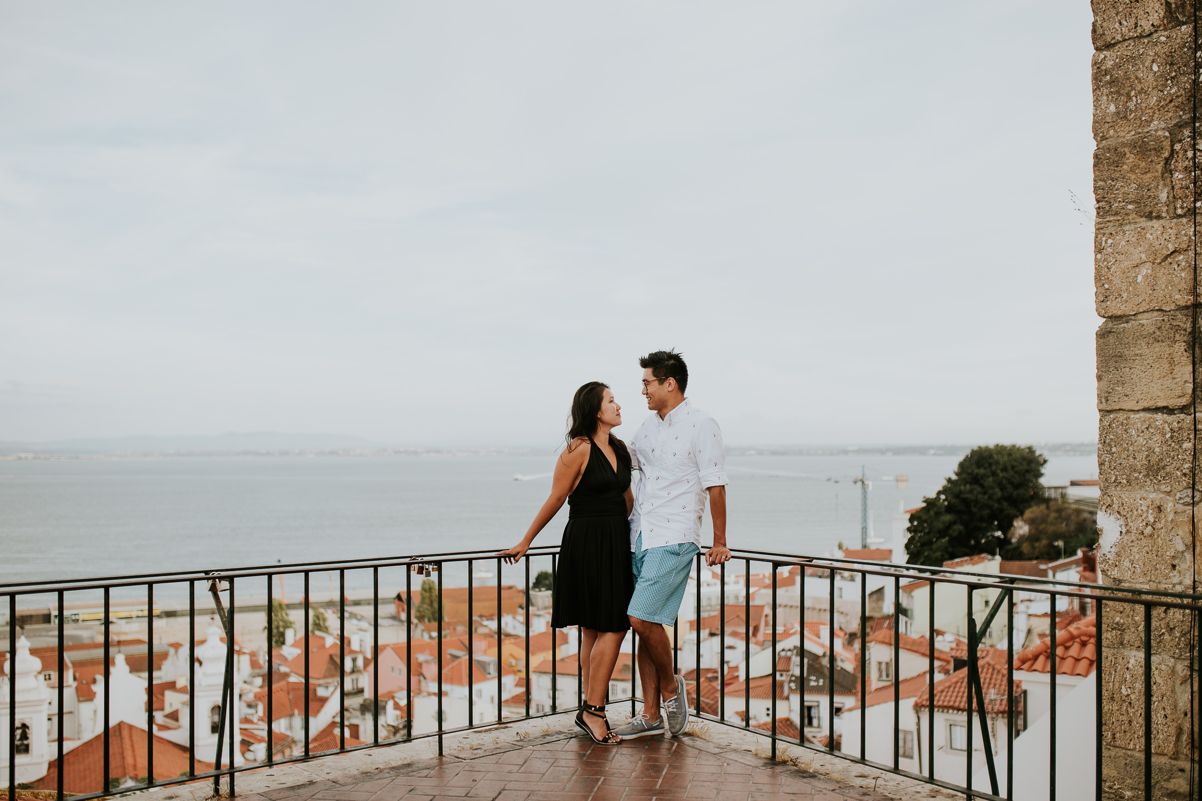 happy boy and girl embraced in lisbon with tejo river as background