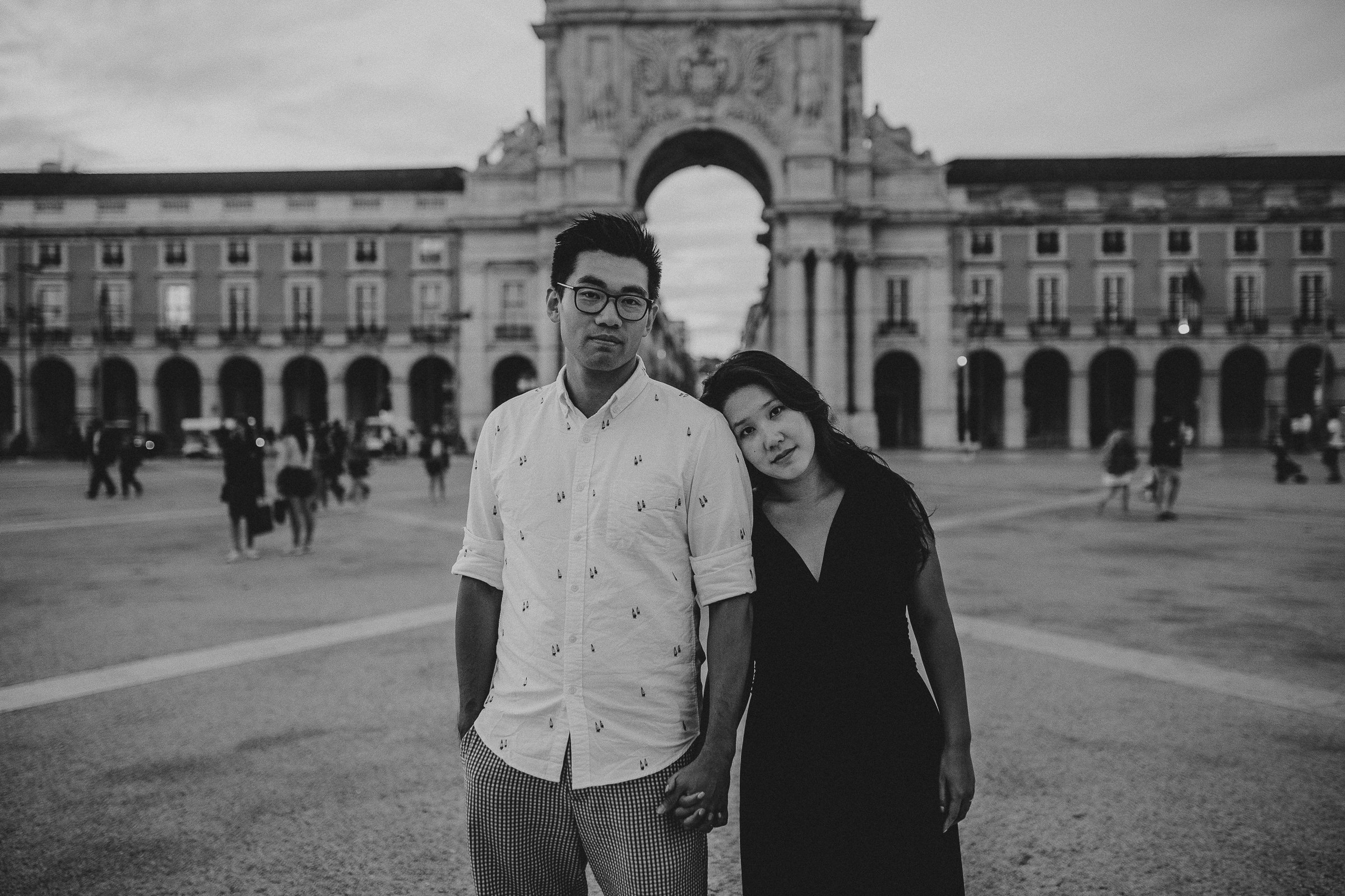 asian couple embraced in front of terreiro do paço, rua augusta, lisbon