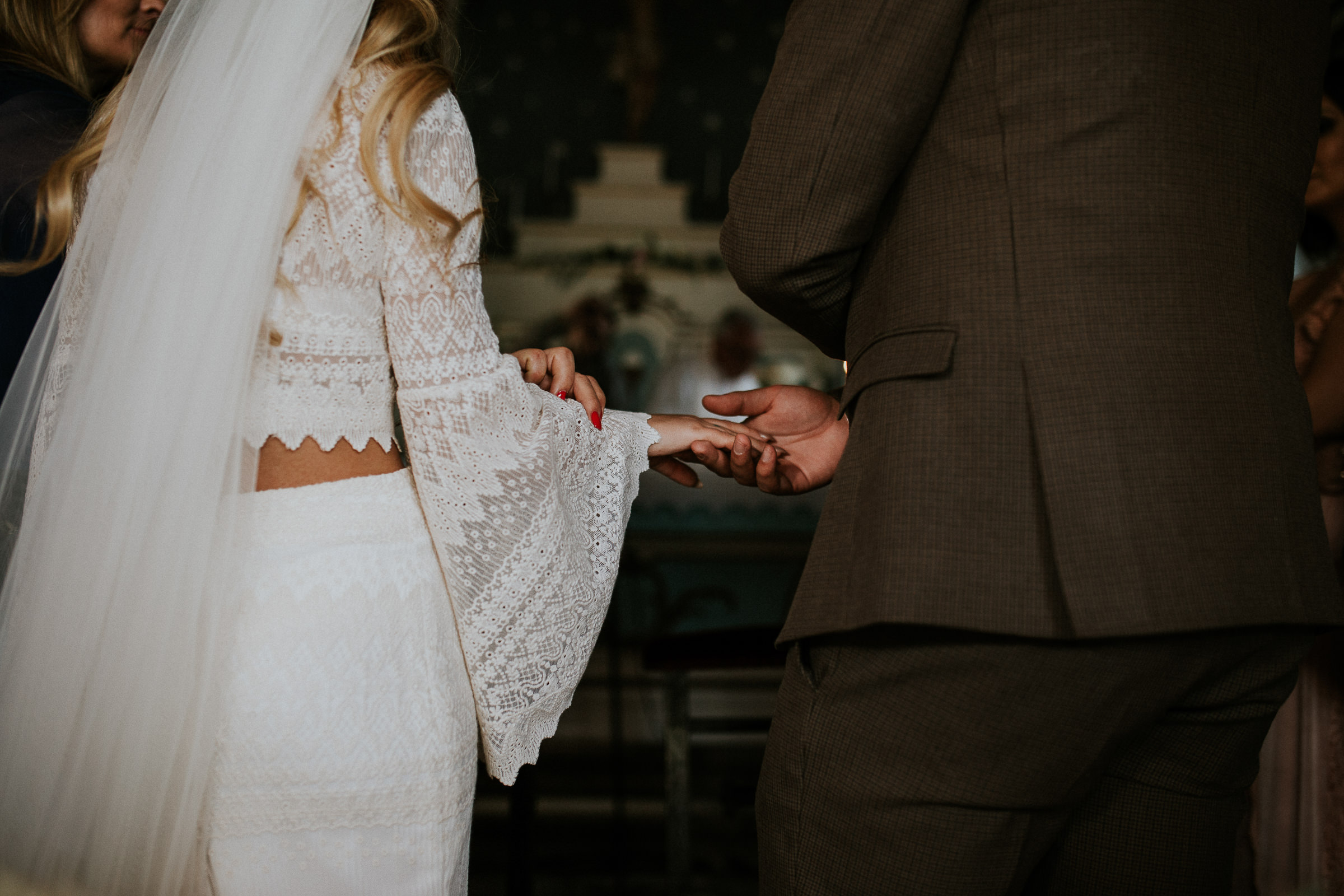 boho chic bride and groom holding hands