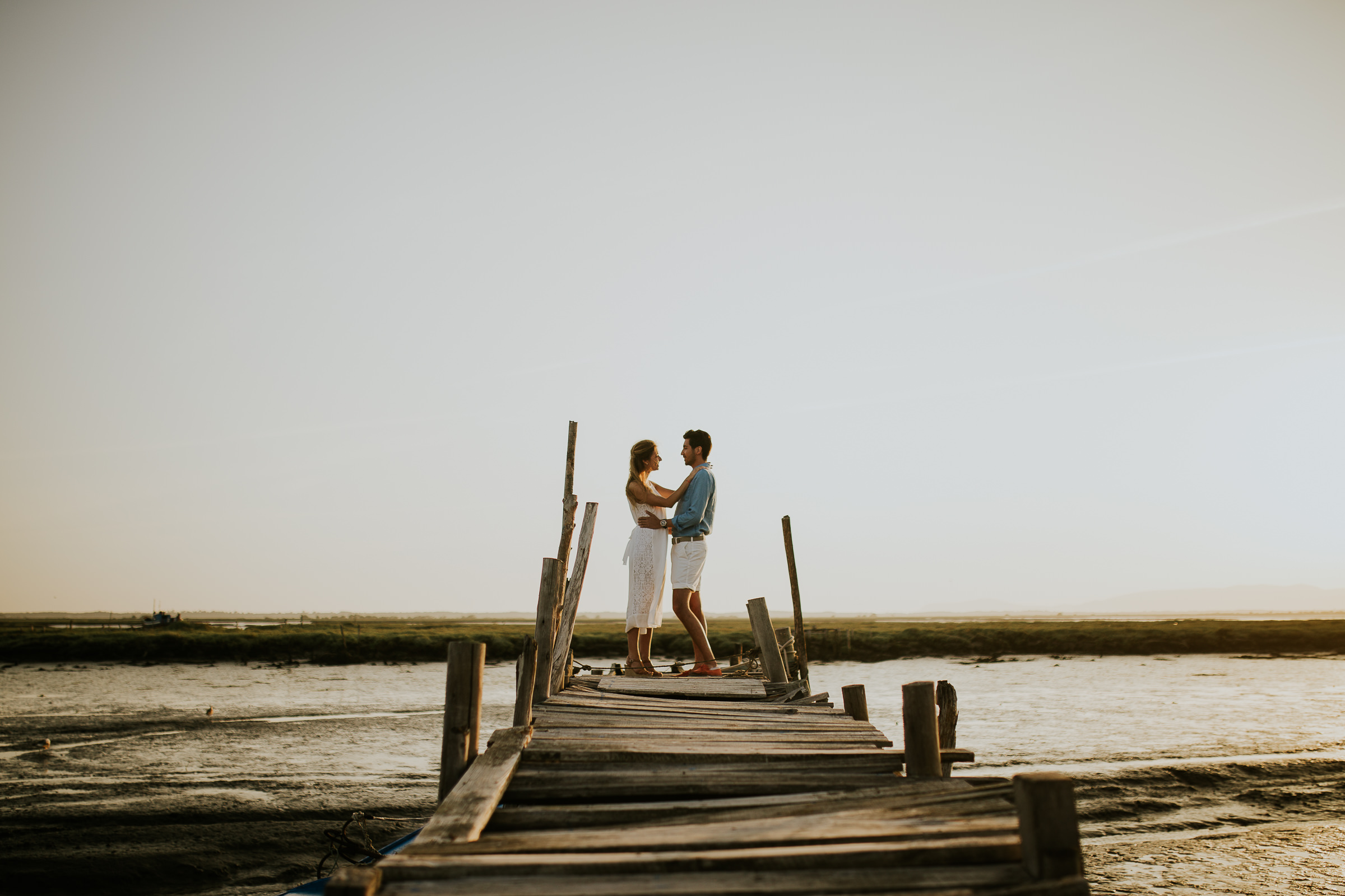 Hugged couple facing each other in a wooden dock