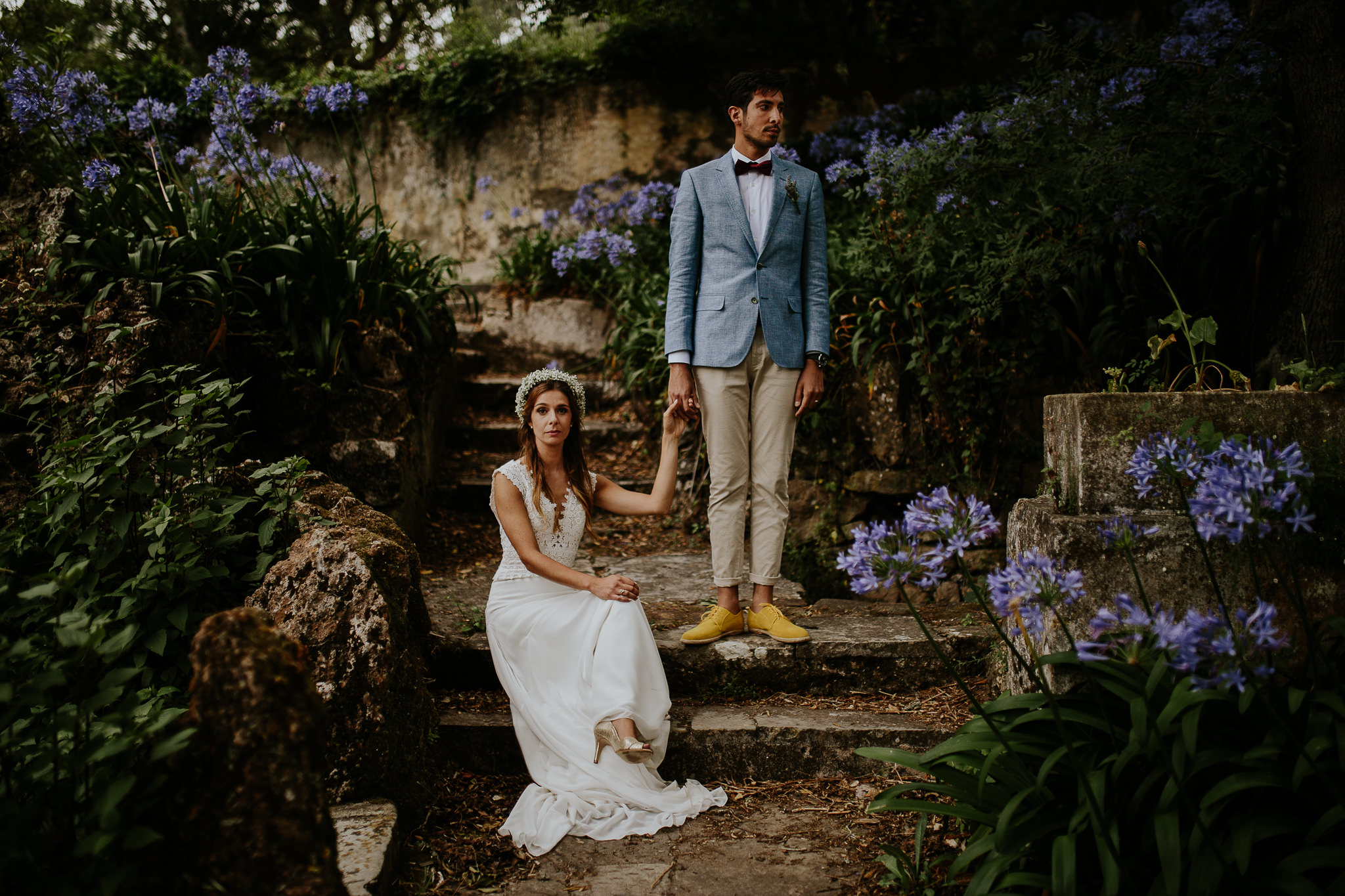 Posed portrait of sited bride and stand up groom on a garden