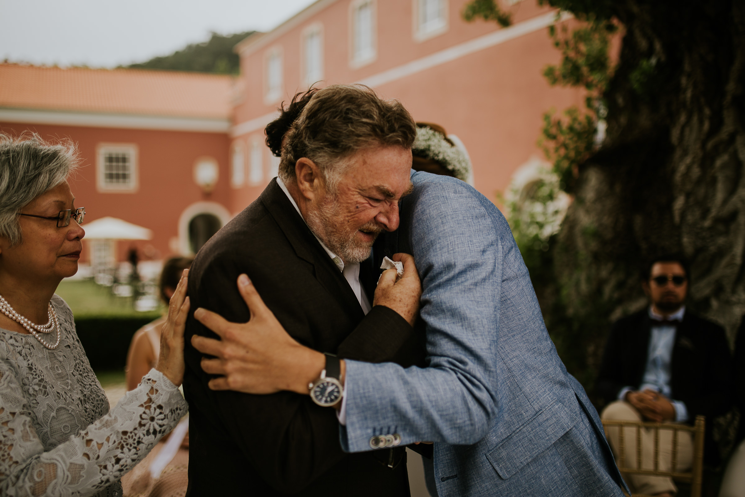 Father and groom hugging and crying